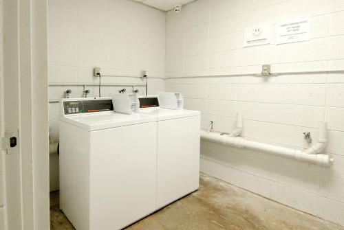 Camera bianca con lavandino e vasca da bagno. di Town and Country INN a Rogers