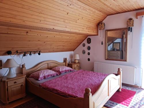 a bedroom with a bed with a wooden ceiling at Holiday House Jasna in Kranjska Gora
