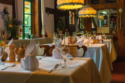 un grupo de mesas con copas de vino y servilletas en Hotel Zum Klosterfischer, en Blankenburg