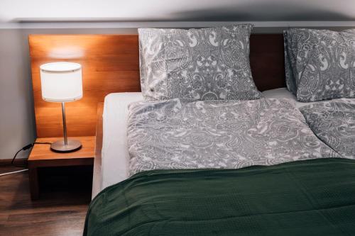 a bedroom with a bed with a lamp and pillows at Apartamenty Madzia in Wisła
