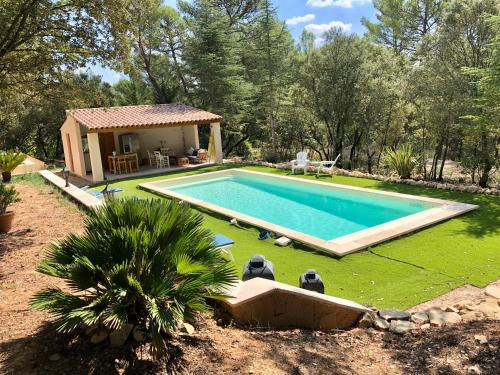 une piscine dans une cour à côté d'une maison dans l'établissement Chambres dans le Luberon - Bois Romay, à La Bastide-des-Jourdans