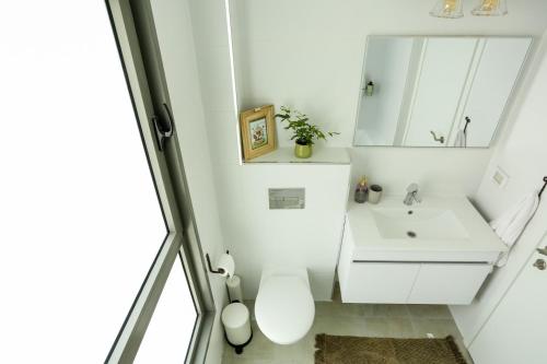 y baño con lavabo blanco y espejo. en פנינה באכזיב- מול הים- achzivacation en Nahariyya