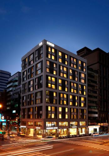 a building on a city street at night at Hotel COZZI Zhongxiao Taipei in Taipei