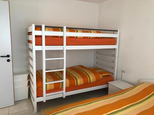 1 dormitorio con 2 literas y 1 cama naranja en Appartamento da 2 locali a Bosco Gurin, en Bosco-Gurin
