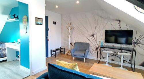 a living room with a blue couch and a television at LE REFLET MERVILLE - Central & chic - AufildeLorient in Lorient