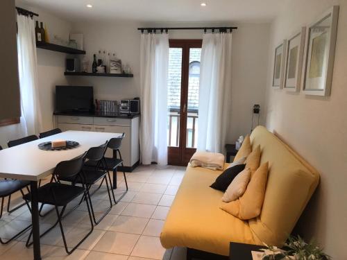 a living room with a yellow couch and a table at Appartamento da 2 locali a Bosco Gurin in Bosco Gurin