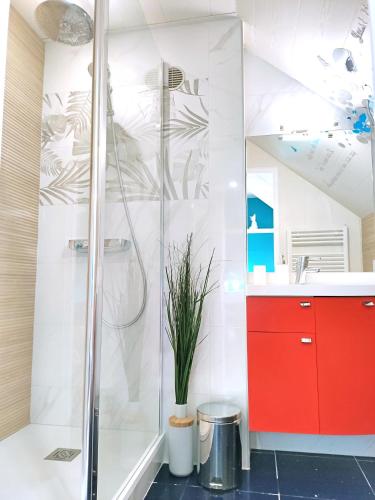 La salle de bains est pourvue d'une douche et d'une armoire rouge. dans l'établissement LE REFLET MERVILLE - Central & chic - AufildeLorient, à Lorient
