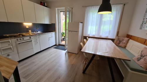 kuchnia z białymi szafkami i drewnianym stołem w obiekcie Appartement Alpenperle w mieście Unterbäch
