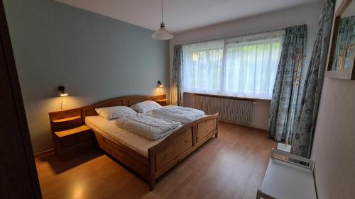 sypialnia z łóżkiem i dużym oknem w obiekcie Appartement Alpenperle w mieście Unterbäch
