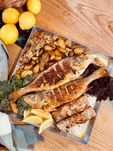 a plate of fish and vegetables on a table at Green Valley vacation homes in Žocenes Ciems