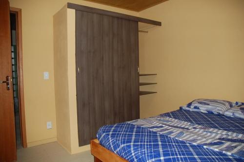 1 dormitorio con 1 cama y puerta de madera en Aguasclaras Residencial, en Manaus