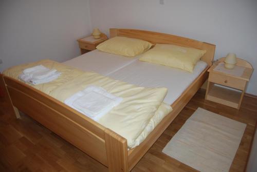 1 dormitorio con 1 cama de madera y 2 mesitas de noche en Apartments Organic tourist farm Jeglijenk, en Šentjanž pri Dravogradu