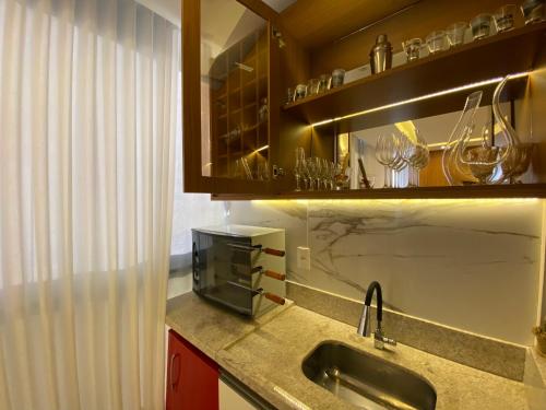 uma cozinha com um lavatório e uma bancada em Itaparica LUXO & DESIGN 24 HORAS em Vila Velha