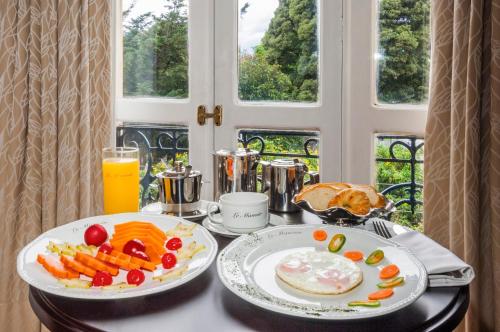 uma mesa com dois pratos de comida e sumo de laranja em Hotel Le Manoir Bogotá em Bogotá