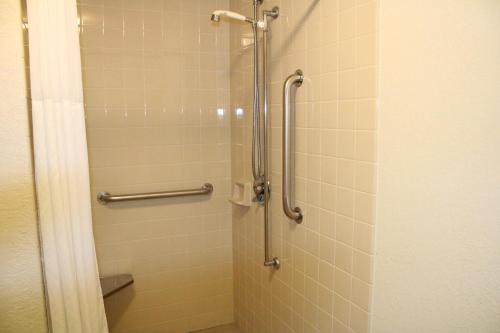 a shower stall in a bathroom withiege tiles at The Oasis Hotel & Bar in Sheboygan Falls