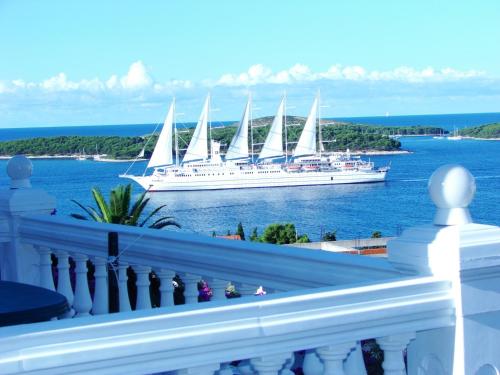 a large white boat on the water with a cruise ship at Apartments Špiko in Hvar