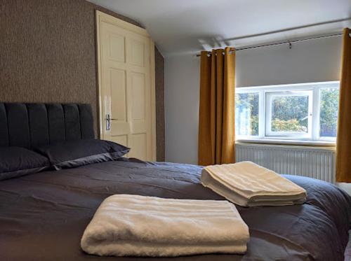 a bedroom with a bed with two towels on it at Racecourse Cottage in Doncaster