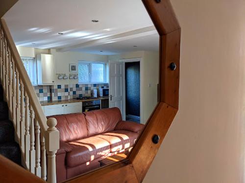 a living room with a brown leather couch at Racecourse Cottage in Doncaster