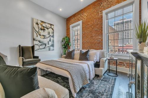 um quarto com uma cama e uma parede de tijolos em The Magnolia em Nova Orleans