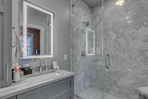 uma casa de banho com um lavatório e uma cabina de duche em vidro. em The Magnolia em Nova Orleans