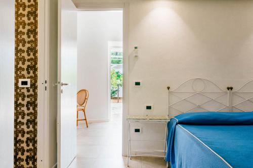 a bedroom with a blue bed and a chair at Villa Favorita Hotel & Events in Marsala