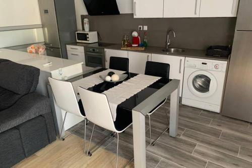 a kitchen with a table and chairs and a washing machine at Para un descanso total in Sant Jaume dels Domenys