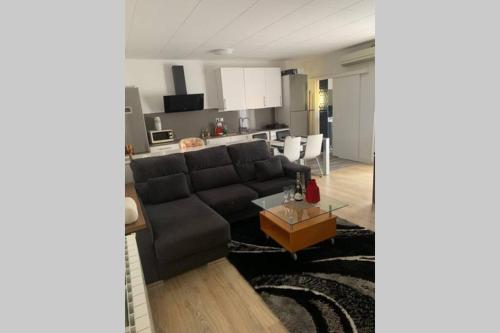 a living room with a couch and a kitchen at Para un descanso total in Sant Jaume dels Domenys