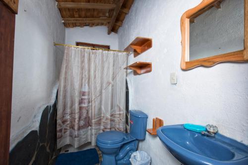 y baño con aseo azul y lavamanos. en Ideal y linda casita en San Cristóbal-Galápagos, en San Cristobal