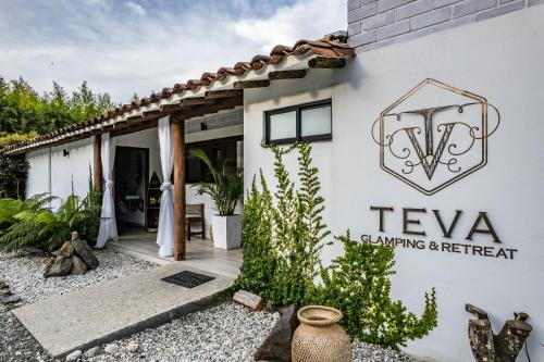 
a building with a sign on the side of it at TEVA Glamping & Retreat in Rionegro
