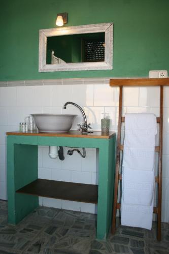 a green bathroom with a sink and a mirror at Hotel Villa Maria in Fuentes de Béjar