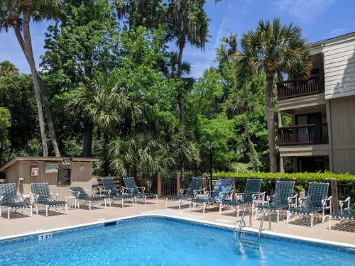 a swimming pool with chairs and a resort at Walk to Coligny Beach Park Family-Friendly Villa in Hilton Head Island