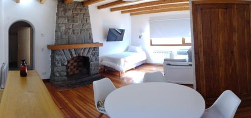 sala de estar con chimenea de piedra y sofá en Casa Laura Dto 1 en San Carlos de Bariloche
