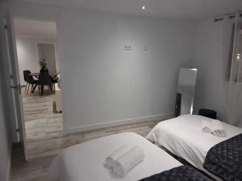 two beds in a room with a dining room at ViLLA DREAMS JF in Arona