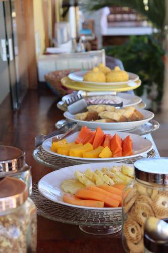 a bunch of plates of food on a table at Pousada Ventos do Guajiru-Casa de Kitesurfistas in Itarema