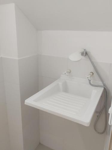 un lavandino bianco da bagno su una parete bianca di Loft 39 a Coveñas