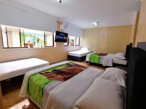 Habitación con 2 camas y TV de pantalla plana. en HOTEL GOLDEN SUITE, en Pereira