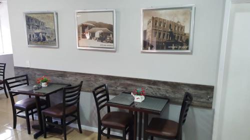 a dining room with tables and chairs and pictures on the wall at Hotel Apiai in Apiaí