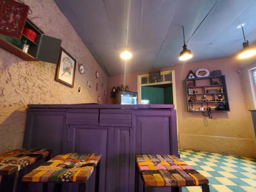 サンタ・アナにあるHotel Brunetteのキッチン(紫色のキャビネット、ベンチ2台付)
