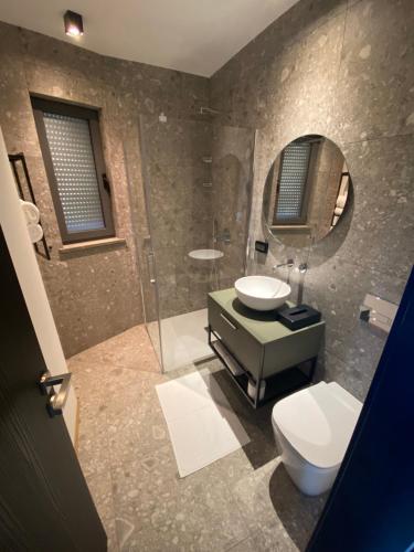 a bathroom with a toilet and a sink and a mirror at Larya House in Dobrovo