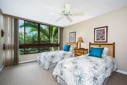 a bedroom with two beds and a window at Keauhou Kona Surf and Racquet Club 2-204 in Kailua-Kona