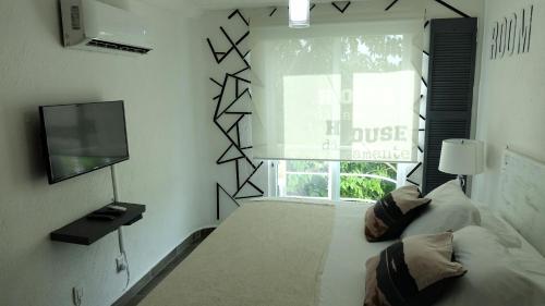 a bedroom with a bed and a tv and a window at Book House Marina Diamante in Acapulco