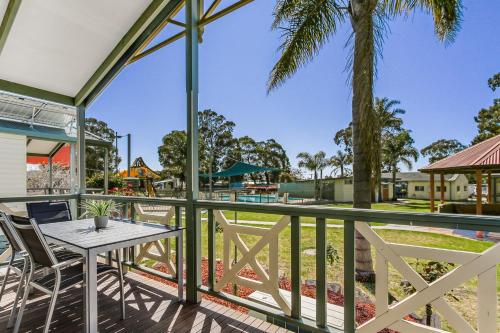 a patio with a table and chairs and a playground at Paynesville Holiday Park in Paynesville