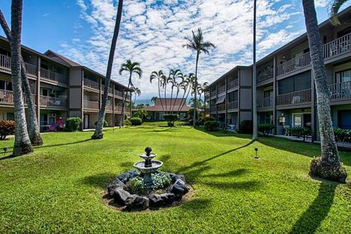 a courtyard with a fountain in the middle of a lawn at Kona Isle E23 in Kailua-Kona