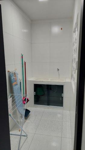 a white room with a fireplace and a chair at Apartamento mobiliado no centro de paulo afonso in Paulo Afonso