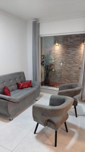 a living room with a couch and two chairs at Apartamento mobiliado no centro de paulo afonso in Paulo Afonso
