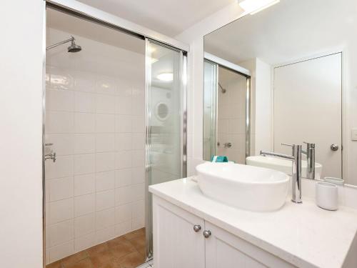 bagno bianco con lavandino e doccia di Calypso Plaza Resort Unit 462 a Gold Coast