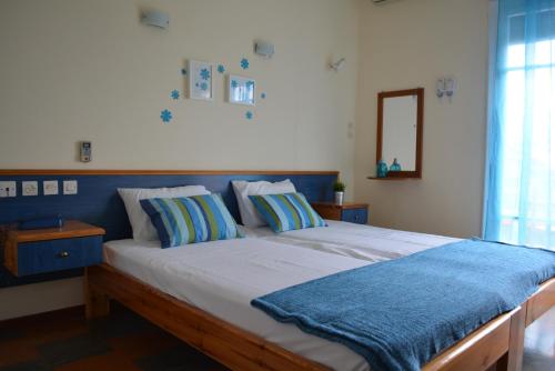 カメナブルナにあるDimitra Hotelのベッドルーム1室(大型ベッド1台、青いヘッドボード付)