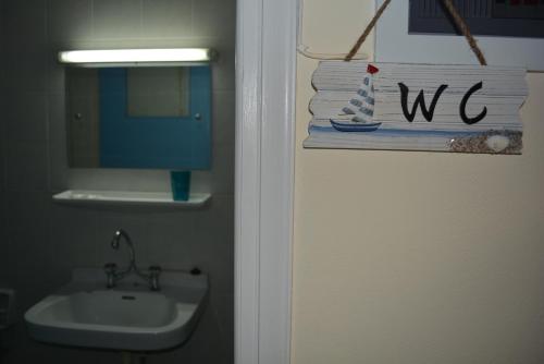 a bathroom with a sink and a sign that says we at Dimitra Hotel in Kamena Vourla