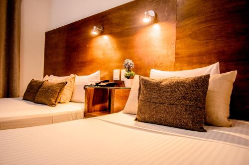 ein Hotelzimmer mit 2 Betten und einem Kopfteil aus Holz in der Unterkunft Hotel del Carmen, en el Centro- DESAYUNO Incluido ! in Tuxtla Gutiérrez