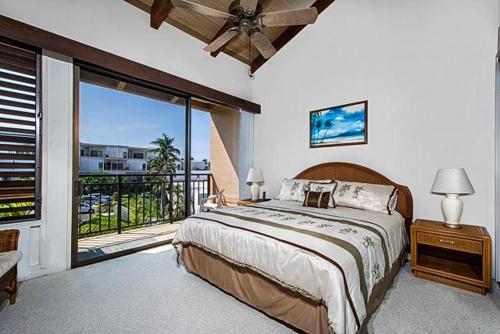 a bedroom with a large bed and a balcony at Kona Makai 3-302 in Kailua-Kona